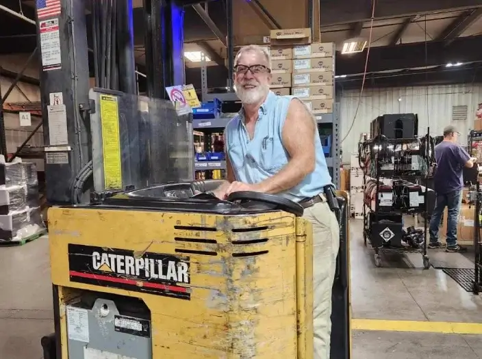 Man worker driving forklift machine smiling