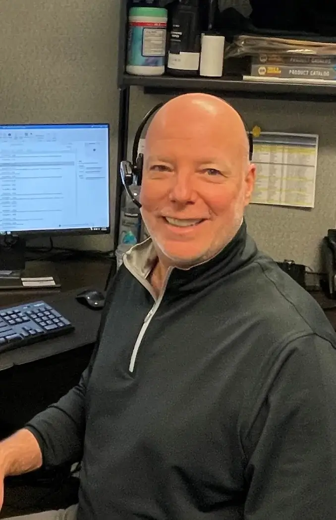happy worker smiling at desk with headphones